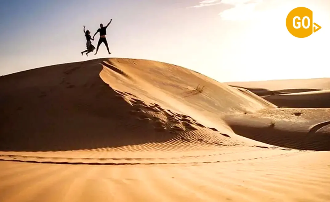 Funny Couple Jumping in Desert Empty Quarter Oman Gallery