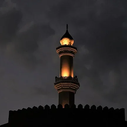 Illuminated mosque minaret at night
